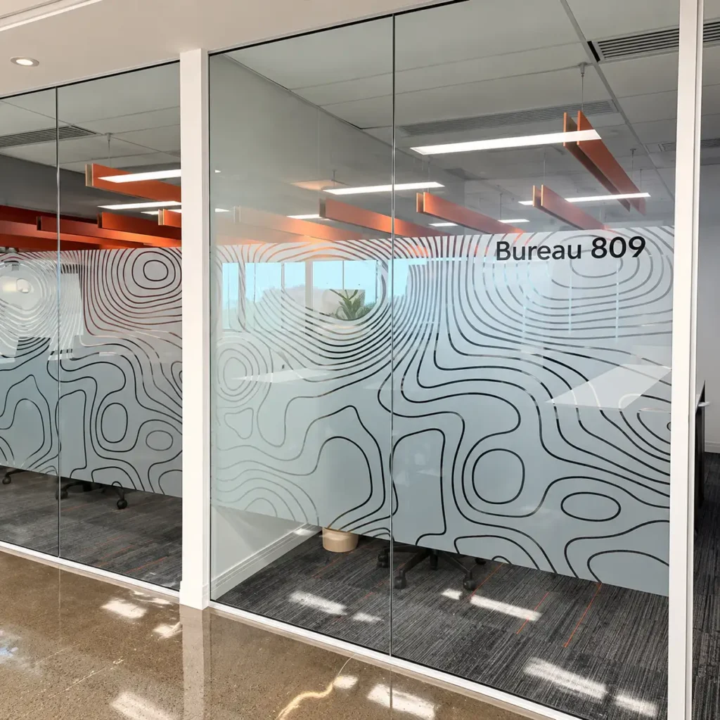 Cloison vitrée de bureau recouverte d'une pellicule décorative à motif de lignes ondulées